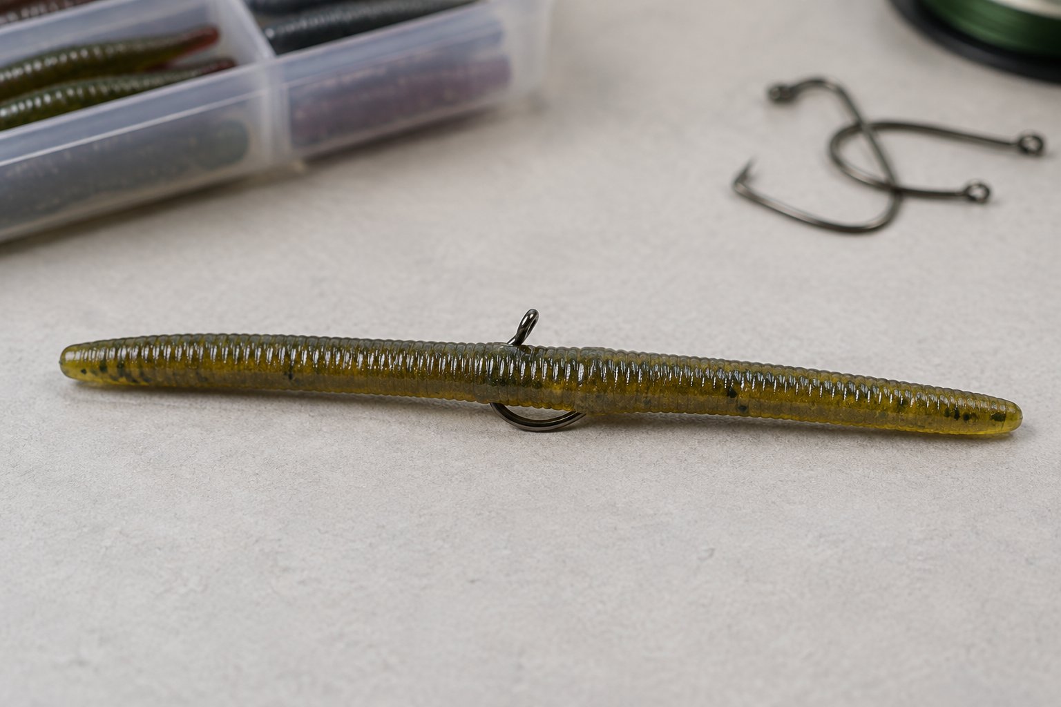 A fishing hook pierced through the middle of a soft-plastic stickbait.