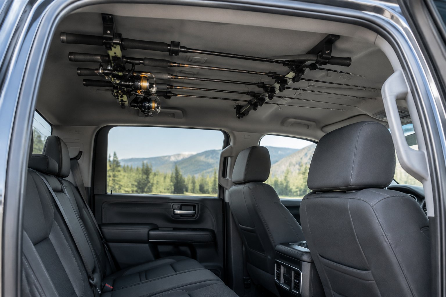 Fishing rods secured in an overhead rack inside a pickup truck.